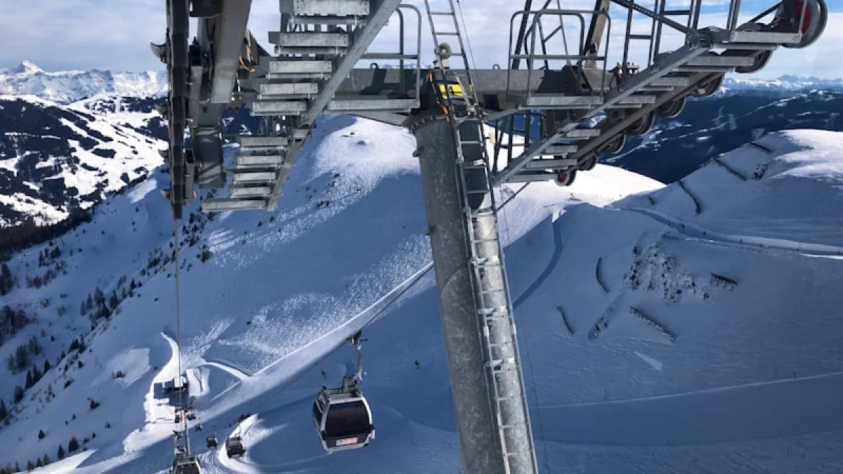 white cable cars overlooking mountain alps