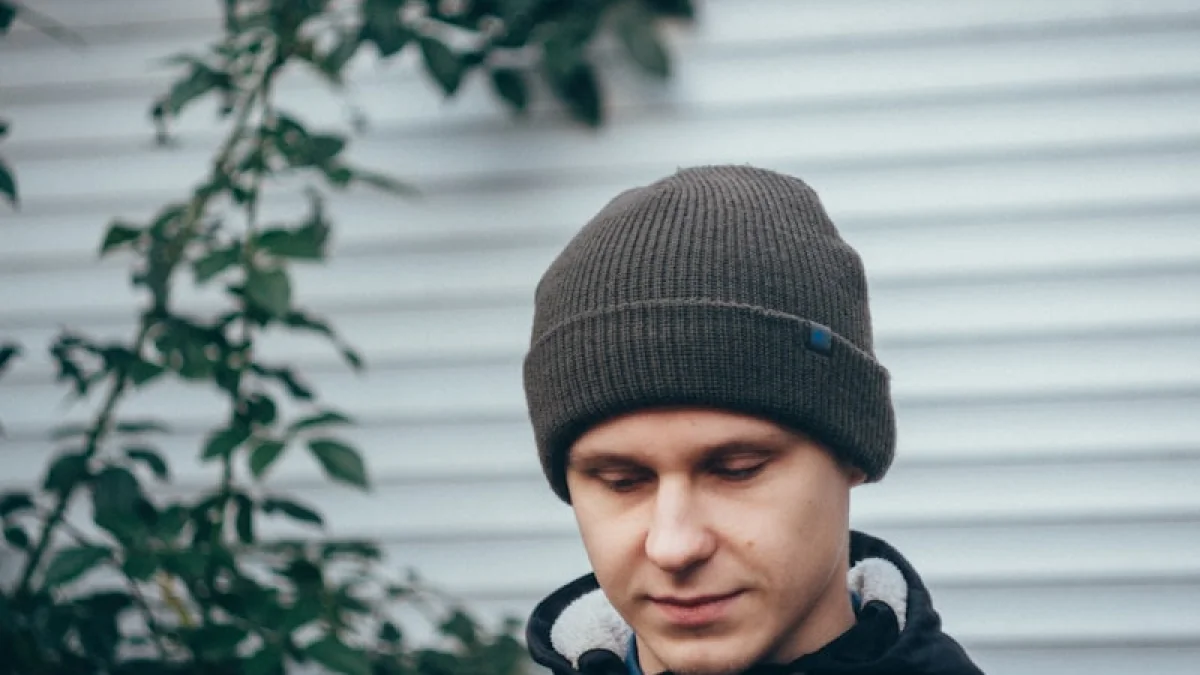man standing near green plant