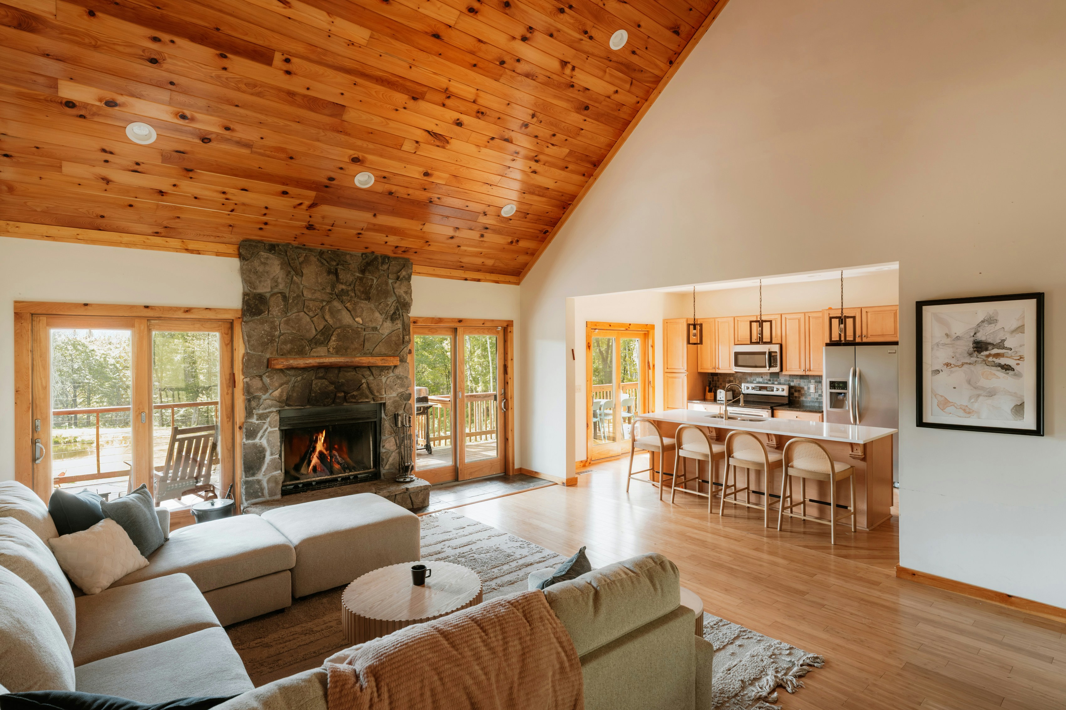 Spacious mountain home living room with a stone fireplace and open kitchen